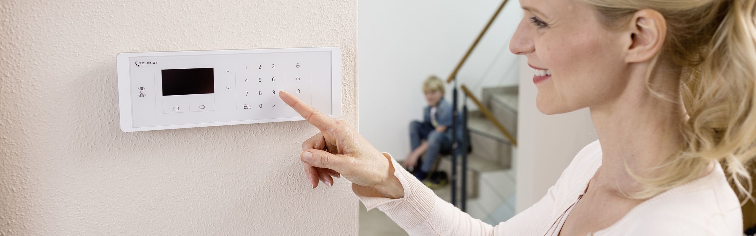 Frau an Bedienteil der Einbruchmeldeanlage - (C) Telenot Alarmsysteme
